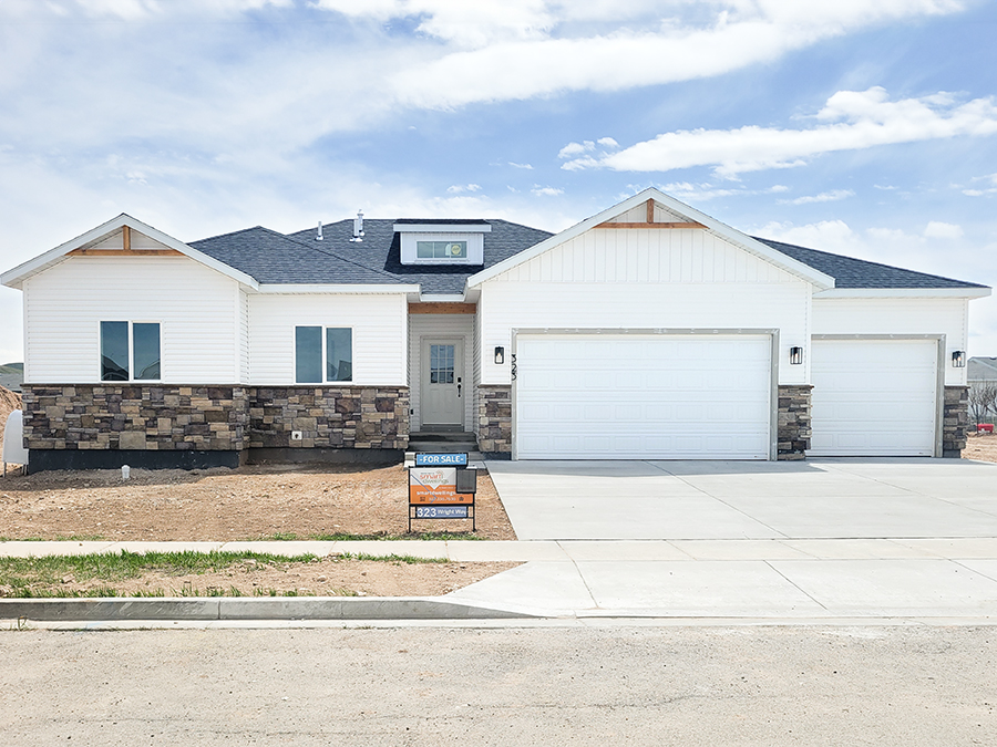 New Ranch 3-bed, 2-bath, 3-car home with unfinished basement. White siding with brown stone accents.